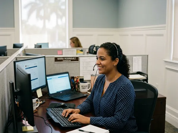 An admissions specialist wearing a headset in a quiet office cubicle, preparing a client for their upcoming stay.