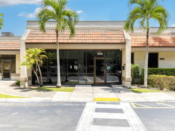 A warm, sunlit entrance of a modern, professional mental health and addiction treatment center in Tamarac, Florida.