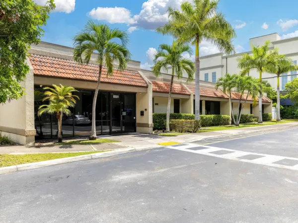 The front exterior building of Destination Hope in Tamarac, Florida, with palm trees and parking area.