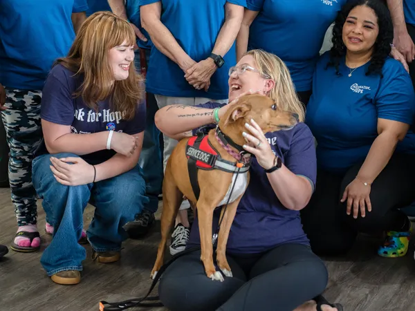 Destination Hope staff members and clients happily interact with a gentle therapy dog, showcasing a holistic and compassionate approach to treatment.