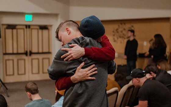 Two people in support program hugging